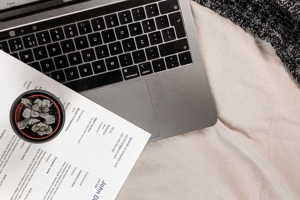 A printed résumé beside a laptop