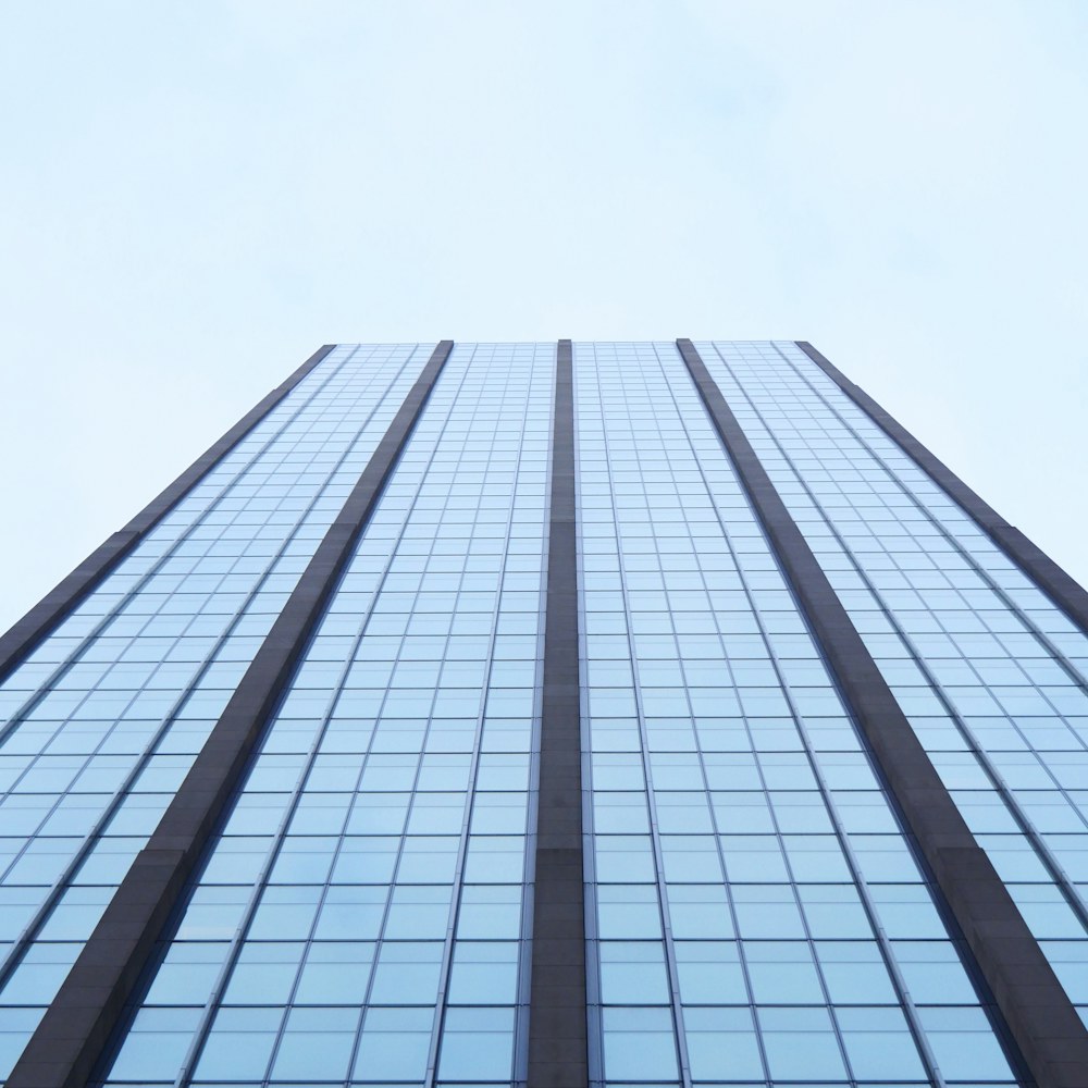 A modern glass tower viewed from below